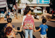 अफशा की कविता woman in blue t shirt carrying red and white backpack walking on street