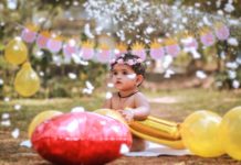 कु.पारुल कुशवाह की कविता photograph of a baby with a flower crown holding balloons